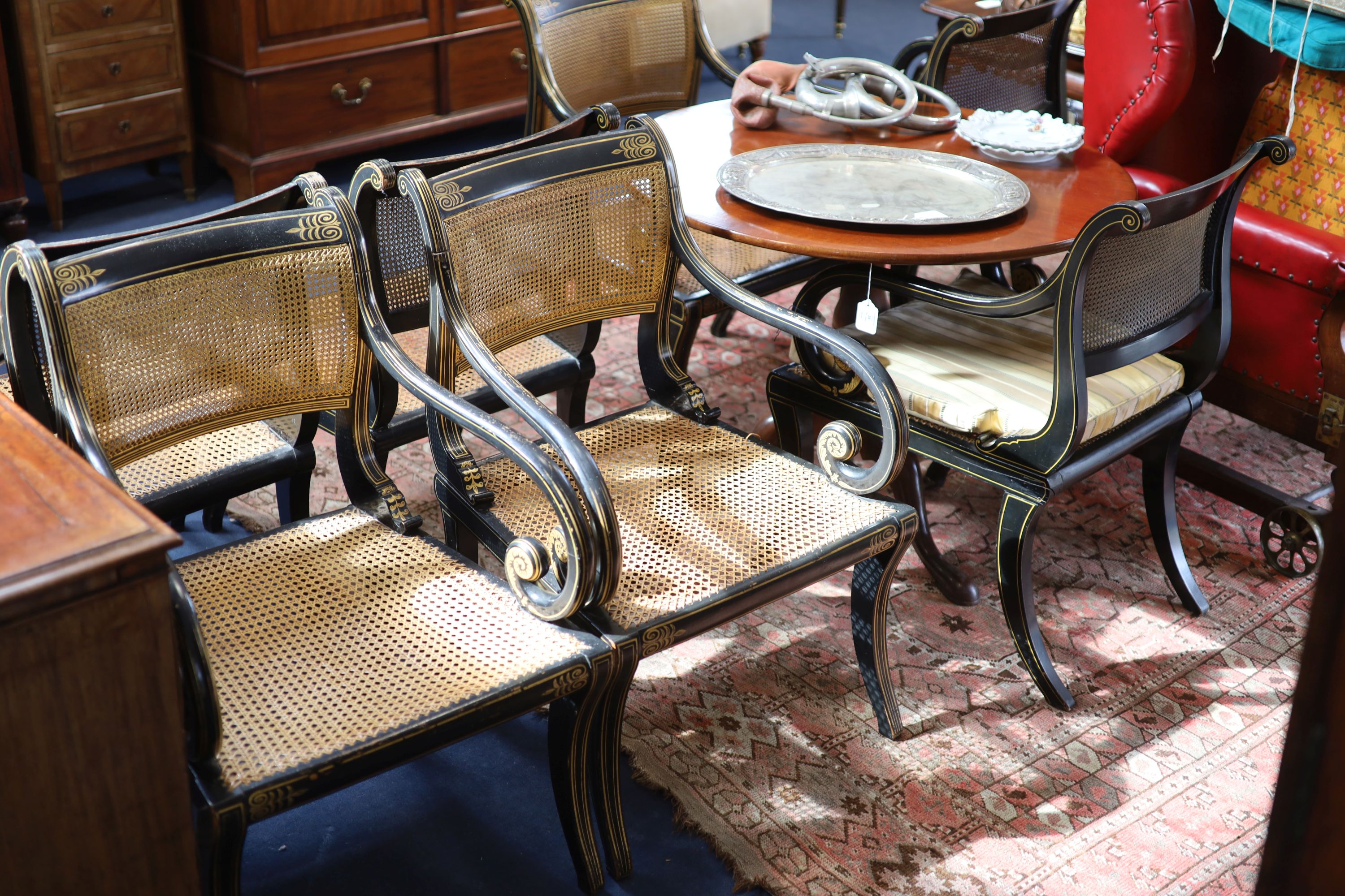 A set of seven Regency style parcel-gilt decorated ebonised armchairs, 19th century,